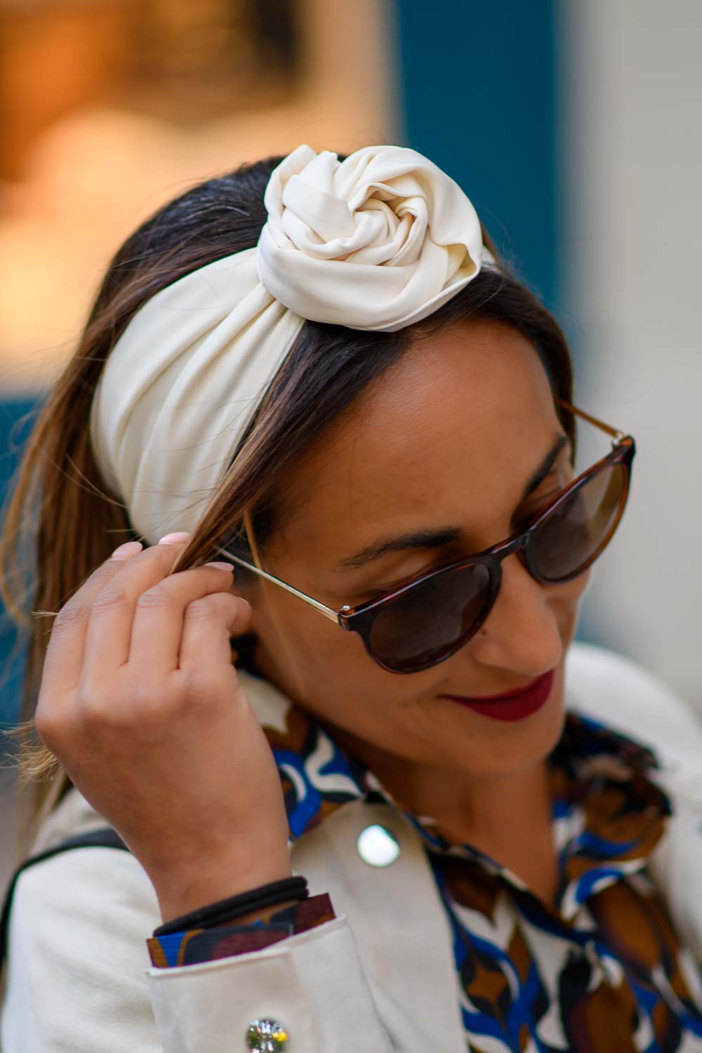 Modèle femme NDJ Occitanie portant le bandeau cheveux Eve crème en satin, noué façon rose africaine, fabrication artisanal.