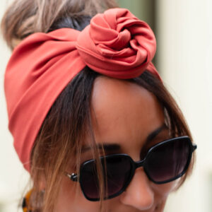NDJ Occitanie-bandeau-cheveux-Bella-Terracotta-2 Modèle femme NDJ Occitanie portant le bandeau cheveux femme Bella noué façon rose africaine en tissu crêpe Georgette de couleur terracotta