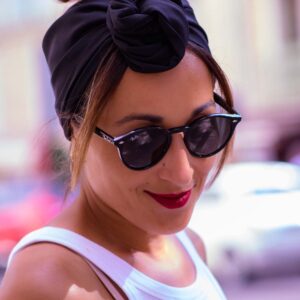 Modèle femme NDJ Occitanie portant le bandeau cheveux noir Jay en satin, noué façon rose africaine, fabrication artisanal.