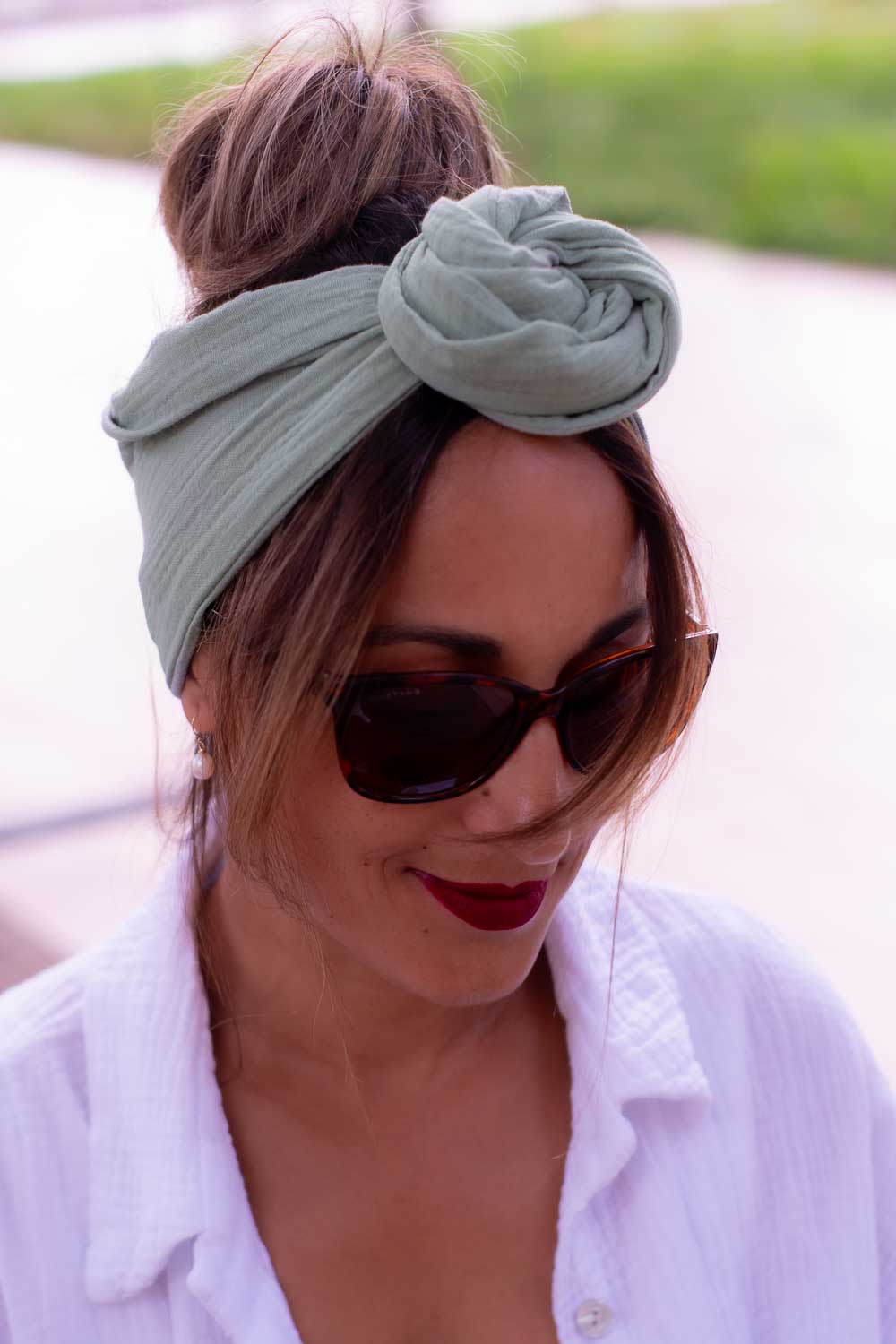 Modèle femme NDJ Occitanie portant le bandeau cheveux femme noué façon rose africaine Jade fabriqué à la main en gaze de coton Kaki.