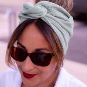 Modèle femme NDJ Occitanie portant le bandeau cheveux femme Jade noué façon turban fabriqué à la main en gaze de coton Kaki.