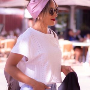Modèle femme NDJ Occitanie portant le bandeau turban rose Livia en satin, noué façon turban, fabrication artisanal.